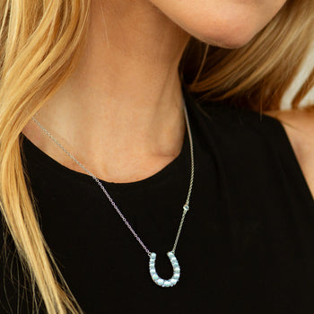 The Horseshoe Necklace with Blue Topaz Over Mother of Pearl