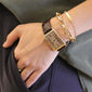 A layered look shown with our 18K yellow gold "Carpe Diem" poesy bracelet